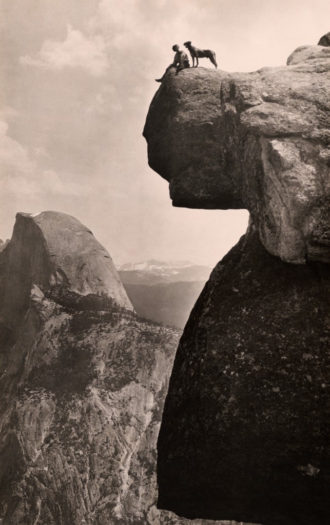 A man and his dog on the Overhanging Rock in Yosemite National Park, May 1924