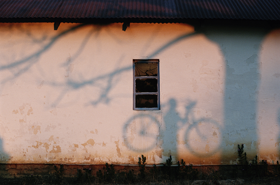 A shadow of a man holding a bicycle is cast on a wall near the Zambezi River, 1996