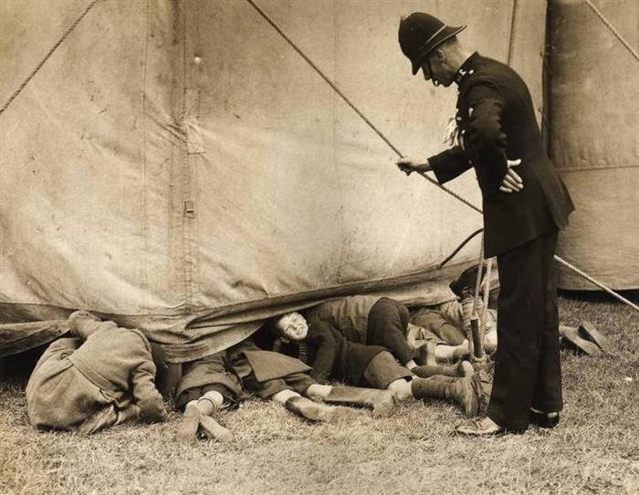 938 - A policeman catches a few youngsters in Luton, England. They were sneaking a look at the Bertram Mill Circus' rehearsals