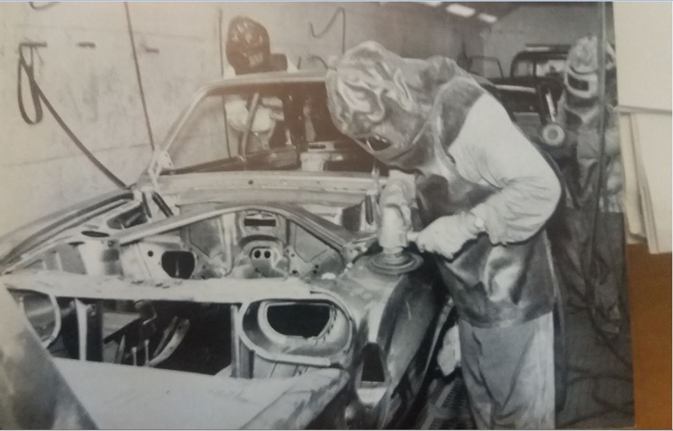 A Ford workman smoothing down the seven pounds of solder used on a motor vehicle